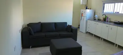 a living room with a black couch and a refrigerator at El cruce - el trapiche in Trapiche