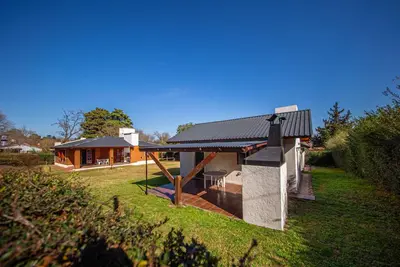 a house with a metal roof on a yard at Cabañas Montecarlo 2 in Santa Rosa de Calamuchita