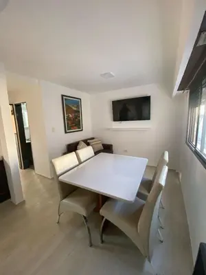 a dining room with a white table and chairs at Departamento cómodo en Córdoba Capital in Cordoba