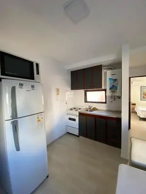 a kitchen with a white refrigerator with a microwave at Departamento cómodo en Córdoba Capital in Cordoba