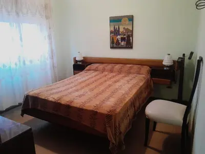a bedroom with a bed and a chair and a window at Departamento en Río Cuarto Cba in Río Cuarto