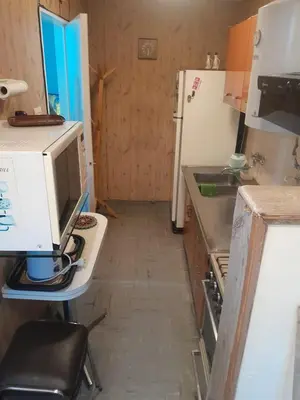 a kitchen with a desk with a computer and a refrigerator at Departamento en Río Cuarto Cba in Río Cuarto