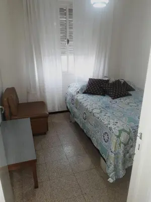 a small bedroom with a bed and a chair at Departamento en Río Cuarto Cba in Río Cuarto