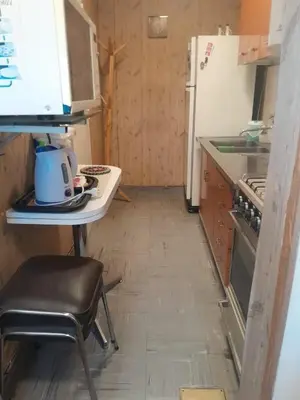 a small kitchen with a table and a refrigerator at Departamento en Río Cuarto Cba in Río Cuarto
