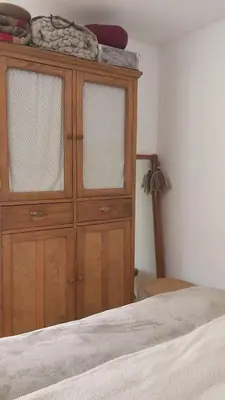 a wooden cabinet in a bedroom with a bed at Paz in Tanti