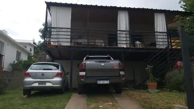 two cars parked in front of a house with a balcony at Paz in Tanti