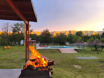 a fire pit in a yard with a pool at Cabañas Vida Paz in Las Calles
