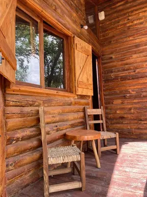 a log cabin with a table and chairs on a porch at Cabaña Rincón de los Pájaros San Ignacio Cordoba in San Ignacio