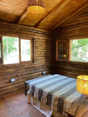 a bedroom with a bed in a wooden cabin at Cabaña Rincón de los Pájaros San Ignacio Cordoba in San Ignacio