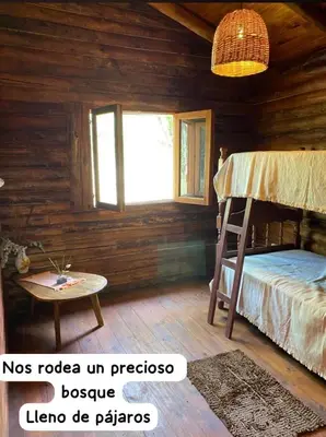 a bedroom with a bunk bed and a table at Cabaña Rincón de los Pájaros San Ignacio Cordoba in San Ignacio