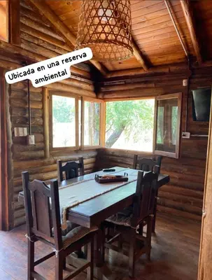 a wooden dining room with a wooden table and chairs at Cabaña Rincón de los Pájaros San Ignacio Cordoba in San Ignacio