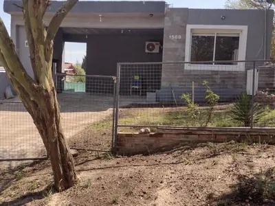 a fence in front of a house with a dog at Portal del rio in Mina Clavero