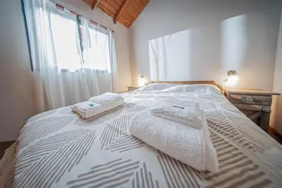 a bedroom with a bed with two towels on it at Cabañas Montecarlo 3 in Santa Rosa de Calamuchita