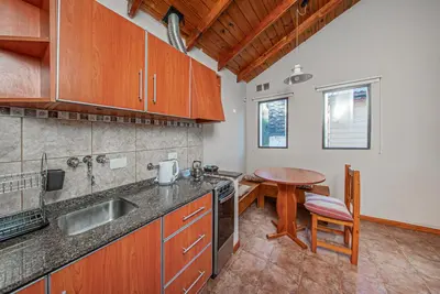 a kitchen with a sink and a table in it at Cabañas Montecarlo 3 in Santa Rosa de Calamuchita