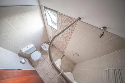 a bathroom with a shower with a toilet and a window at Cabañas Montecarlo 3 in Santa Rosa de Calamuchita