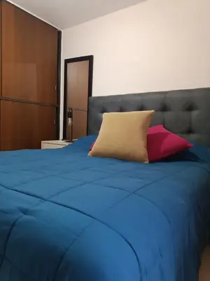 a blue bed with two pillows on top of it at Departamento en zona Güemes in Cordoba