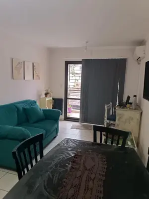 a living room with a green couch and a table at Departamento en zona Güemes in Cordoba