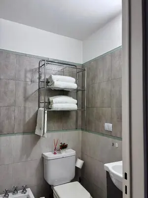 a bathroom with a toilet and a sink and towels at Departamento Frente Campus UNC in Cordoba