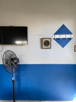 a room with a fan and a wall with a tv at La loreta in Mina Clavero