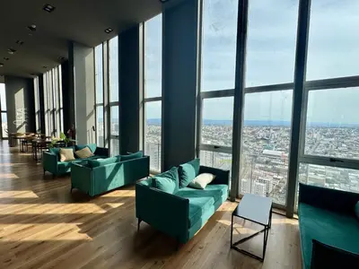 a room with couches and chairs in a building with windows at Rent a flat - Alto Paz Tower in Cordoba