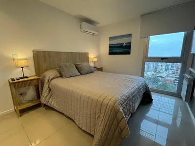 a bedroom with a bed and a large window at Rent a flat - Alto Paz Tower in Cordoba