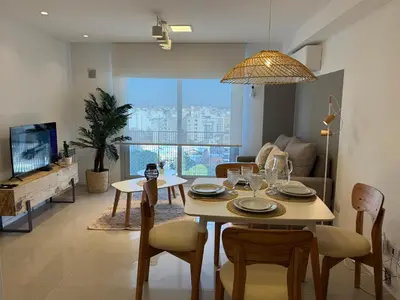 a living room with a table and chairs and a tv at Rent a flat - Alto Paz Tower in Cordoba