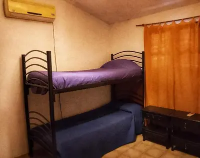 a bedroom with two bunk beds with purple sheets at Cómoda y Espaciosa Casa Céntrica Frente al Lago San Roque - Carlos Paz in Villa Carlos Paz