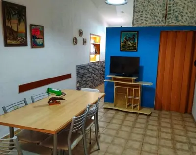 a dining room with a table and a television at Cómoda y Espaciosa Casa Céntrica Frente al Lago San Roque - Carlos Paz in Villa Carlos Paz