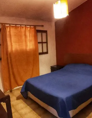 a bedroom with a blue bed and a window at Cómoda y Espaciosa Casa Céntrica Frente al Lago San Roque - Carlos Paz in Villa Carlos Paz