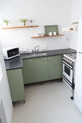 a kitchen with green cabinets and a sink at Aires del Casco in La Porteña