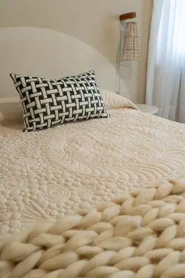 a bed with a white comforter and a pillow at Aires del Casco in La Porteña