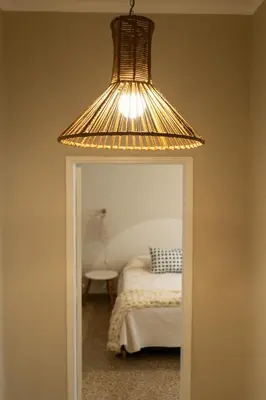 a light hanging over a mirror in a bedroom at Aires del Casco in La Porteña
