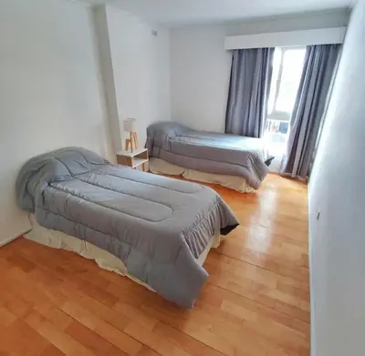 a bedroom with two beds and a wooden floor at Departamento en calle Independencia in Cordoba