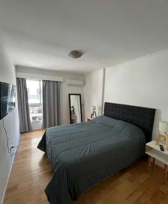 a bedroom with a large bed and a television at Departamento en calle Independencia in Cordoba