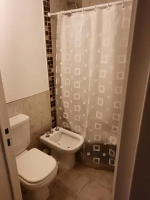a bathroom with a toilet and a shower curtain at Terra Zión in Cordoba