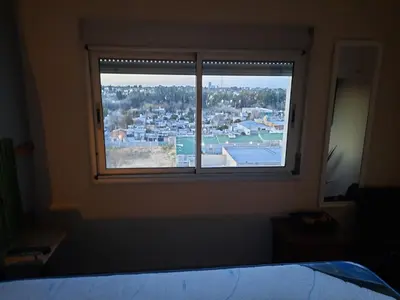 a bedroom window with a view of a city at Terra Zión in Cordoba