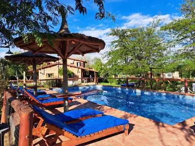 a swimming pool with lounge chairs and an umbrella at complejo inti sumah in Nono