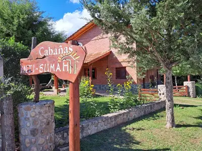 a sign in front of a log cabin at complejo inti sumah in Nono