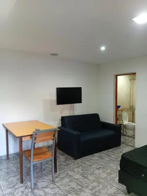 a living room with a black couch and a table at Monoambiente Amoblado in Cordoba