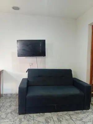 a black couch in a room with a tv at Monoambiente Amoblado in Cordoba
