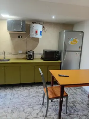 a kitchen with a refrigerator and a wooden table at Monoambiente Amoblado in Cordoba