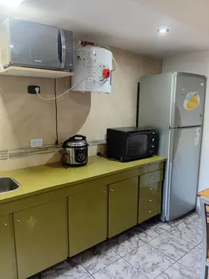 a kitchen with a microwave and a refrigerator at Monoambiente Amoblado in Cordoba