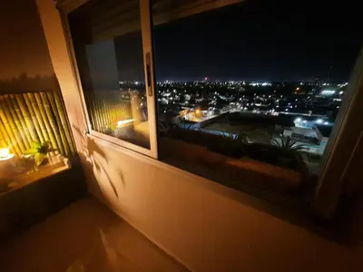 a window with a view of a city at night at Terra Zión in Cordoba