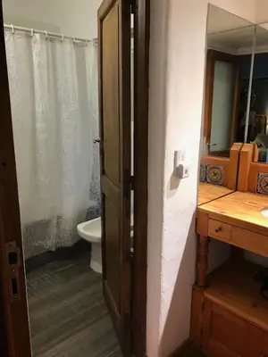 a bathroom with a toilet and a sink and a mirror at Casa de campo con piscina, limpieza y desayuno in Río Cuarto