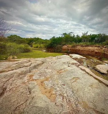 a large rock on the side of a river at Casa de campo con piscina, limpieza y desayuno in Río Cuarto