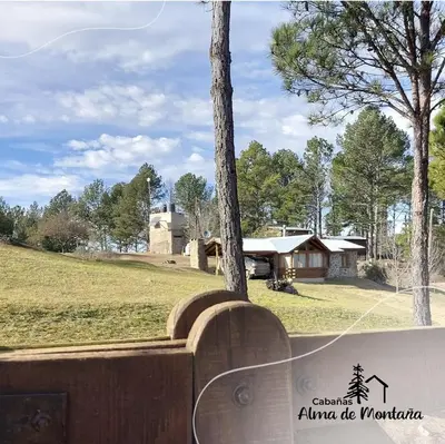 a wooden bench in front of a house at Cabañas Alma de Montaña