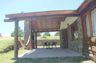 a patio of a house with chairs and a hammock at Cabañas Alma de Montaña