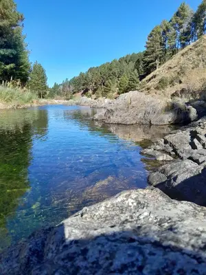 a river with some rocks in the water at Cabañas Alma de Montaña