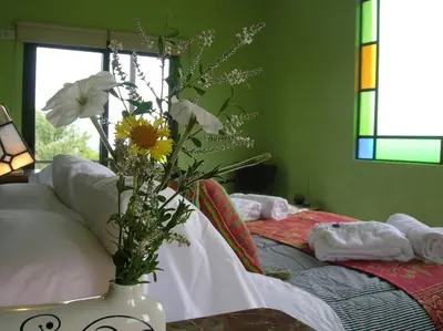 a vase with flowers on a table in a bedroom at Apart Los Antiguos in Merlo