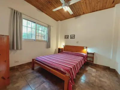 a large bed in a room with a ceiling at Complejo Lago Chico in Tanti